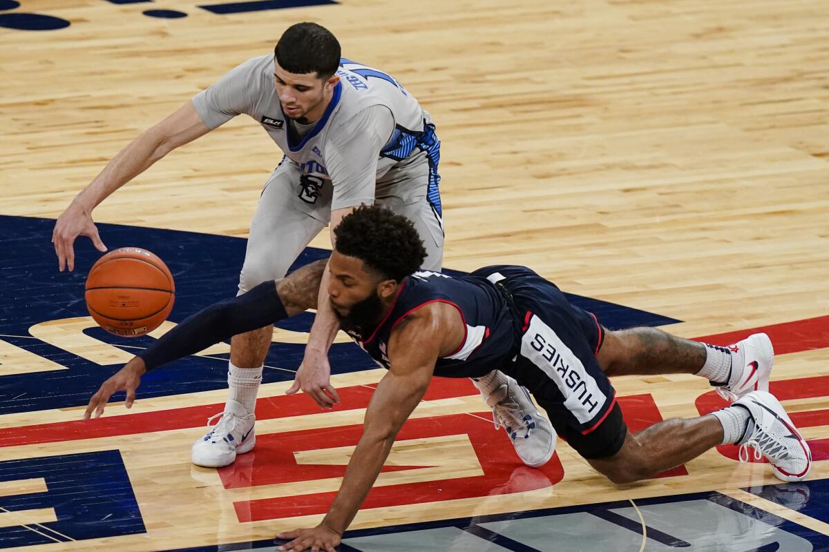Connecticut's R.J. Cole, bottom, and Creighton's Marcus Zegarowski battle for the ball March 12, 2021.