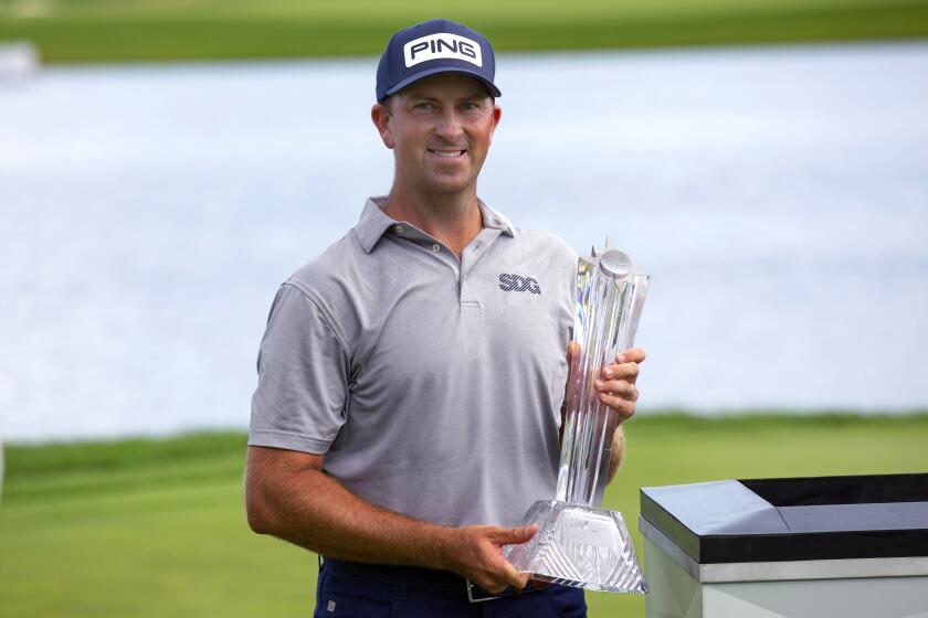 Michael Thompson holds the trophy after winning the 3M Open golf tournament in Blaine, Minn.