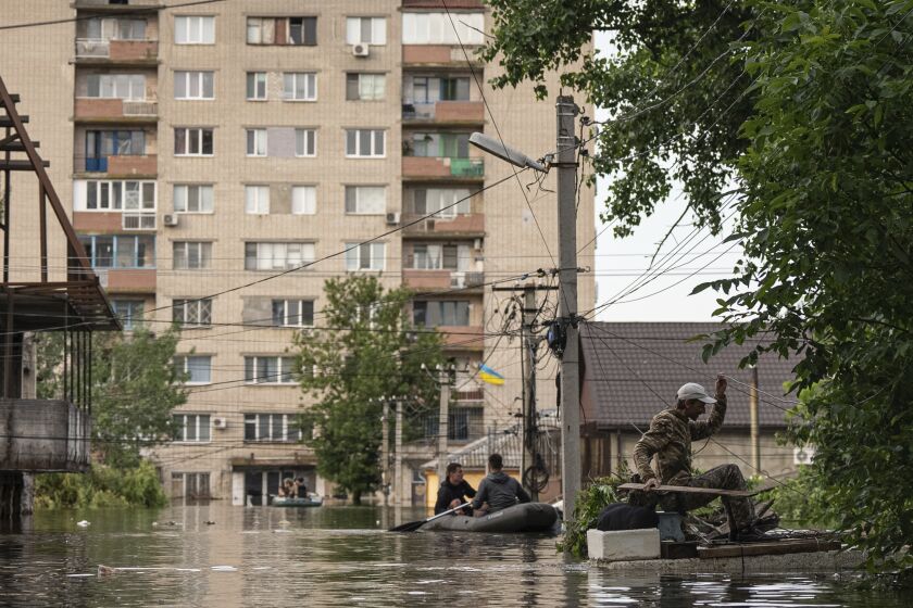 A man gets to his flooded house in Kherson, Ukraine, Thursday, June 8, 2023. Floodwaters from a collapsed dam kept rising in southern Ukraine on Wednesday, forcing hundreds of people to flee their homes in a major emergency operation that brought a dramatic new dimension to the war with Russia, now in its 16th month. (AP Photo/Evgeniy Maloletka)