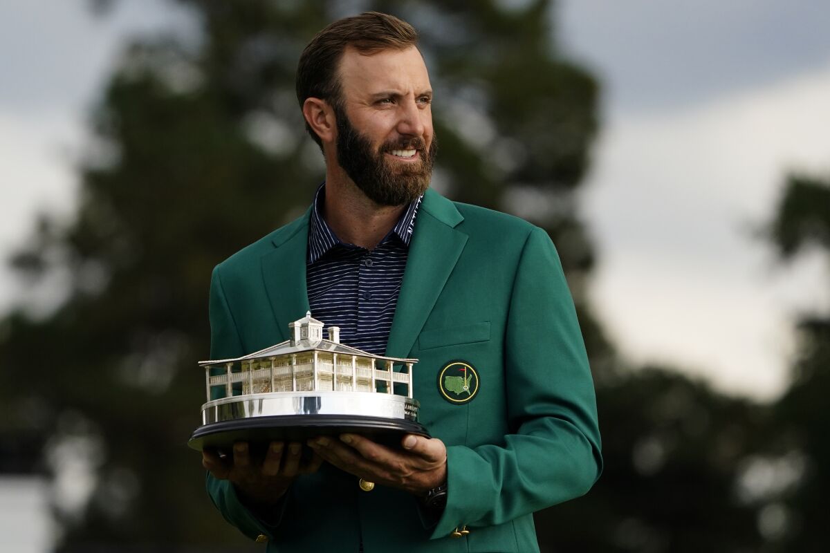 Masters golf champion Dustin Johnson holds the tournament trophy after his victory Sunday.