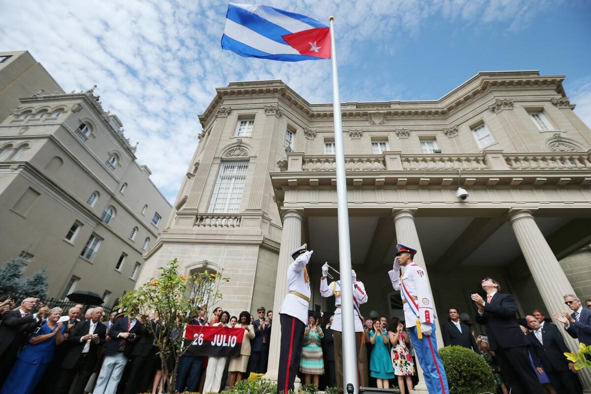 Cuban Foreign Minister Bruno Rodriguez applauds as the Cuban flag is raised in front of the country's embassy in Washington on July 20, 2015.