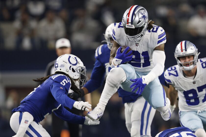 Dallas Cowboys' Ezekiel Elliott (21) runs against Indianapolis Colts' Stephon Gilmore (5) during the first half of an NFL football game, Sunday, Dec. 4, 2022, in Arlington, Texas. (AP Photo/Ron Jenkins)