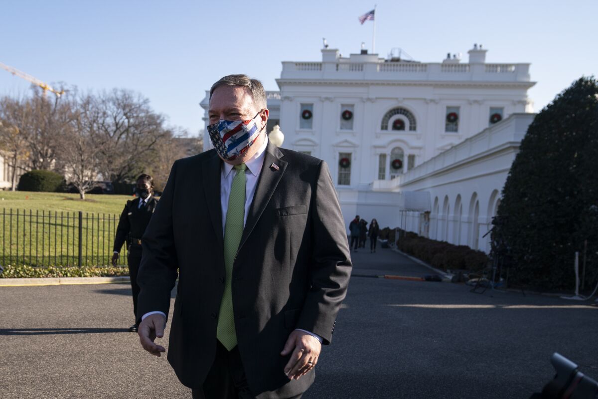 Mike Pompeo, in mask, stands outside the White House.
