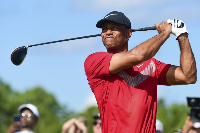 FILE - Tiger Woods follows his ball at the fourth tee during the last round of the Hero World Challenge at Albany Golf Club in Nassau, Bahamas, Saturday, Dec. 7, 2019. Tiger Woods has another loaded field for his Hero World Challenge in the Bahamas. Woods on Tuesday, Oct. 4, 2022, announced 17 players for the 20-man field, and all but four are from the top 21 in the world ranking. Still to be announced is whether the player at No. 1,195 in the world — Woods — will tee it up at Albany.(AP Photo/Dante Carrer, File)