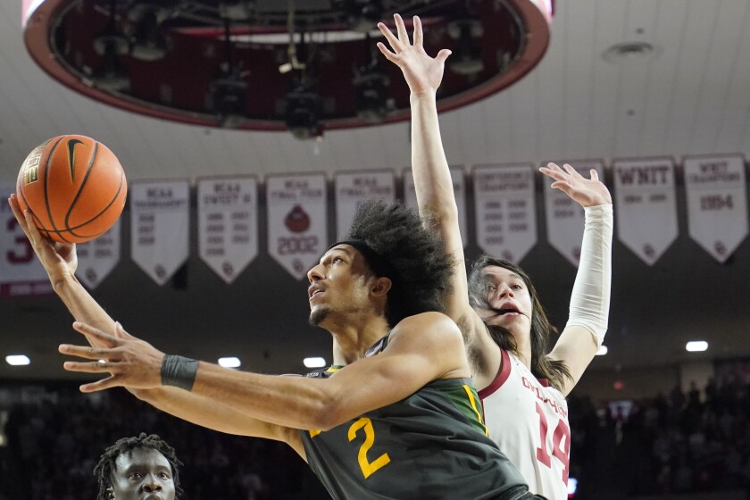 Baylor guard Kendall Brown (2) goes to the basket past Oklahoma guard Bijan Cortes (14) in the first half of an NCAA college basketball game Saturday, Jan. 22, 2022, in Norman, Okla. (AP Photo/Sue Ogrocki)