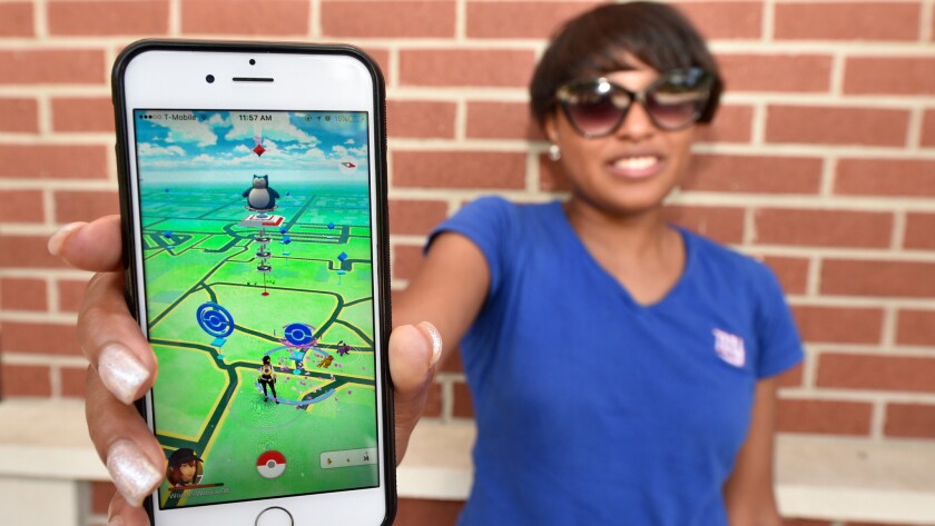 Keyanna Arnett poses with the Pokémon Go game on her cell phone at Augusta University in Augusta, Ga.
