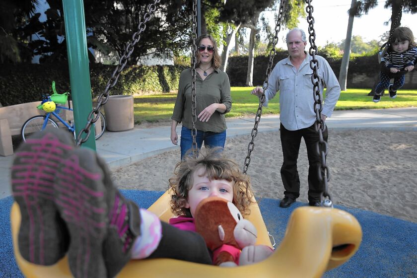 Vanessa Leddy, 2, swings as parents Christy Lambertson, left, and John Leddy watch at Culver West Park. The family decided against a child-care center in Santa Monica because of its low measles vaccination rate.
