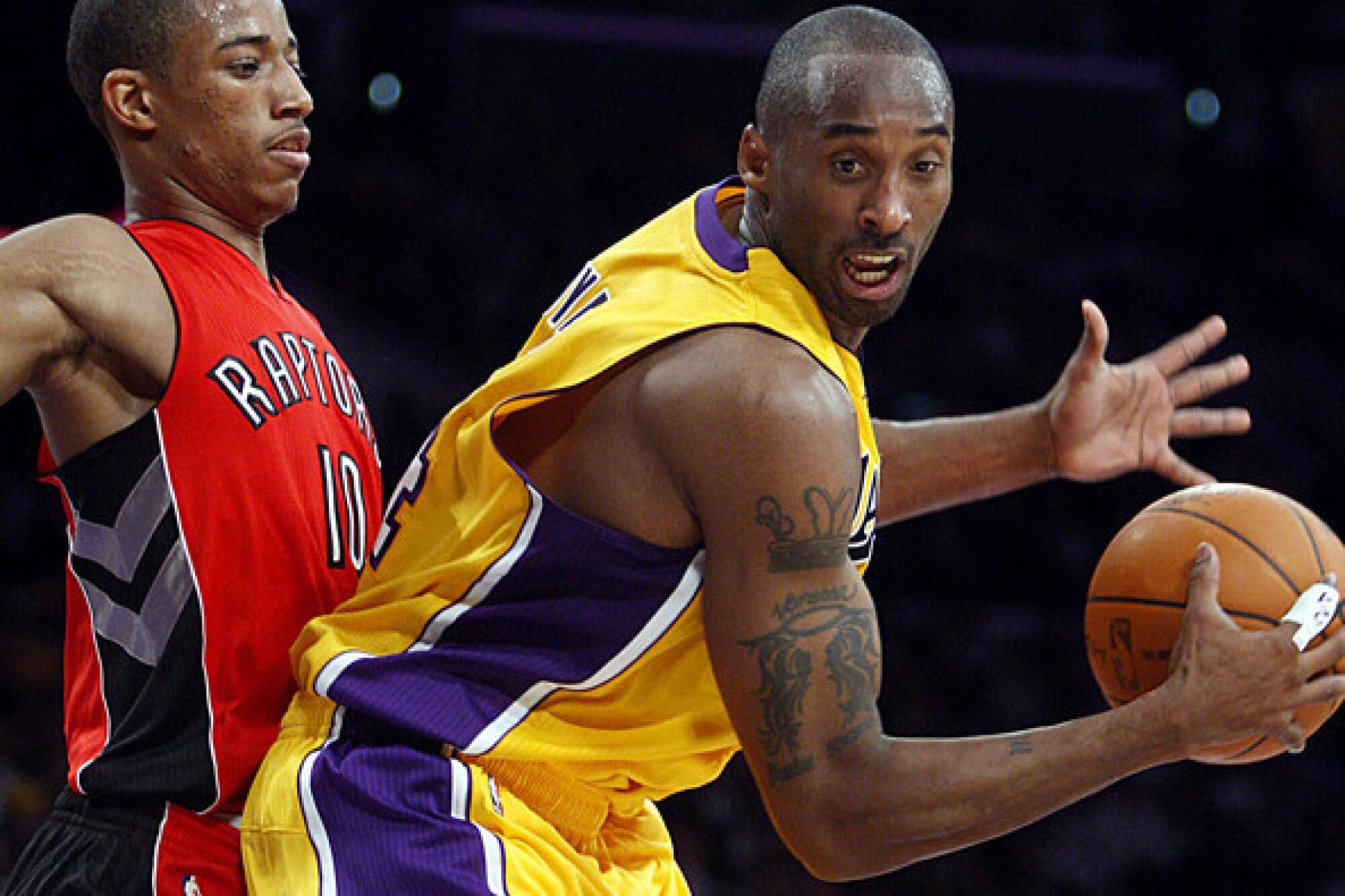 Lakers guard Kobe Bryant receives a pass while guarded by Raptors guard DeMar DeRozan.