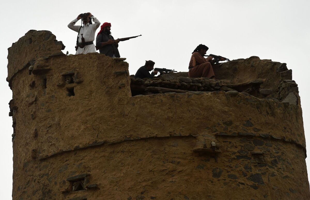 Armed Saudi volunteers from the Fayfa tribes stand atop an ancient tower during a tribal gathering in Jizan province, near the border with Yemen, on Tuesday.