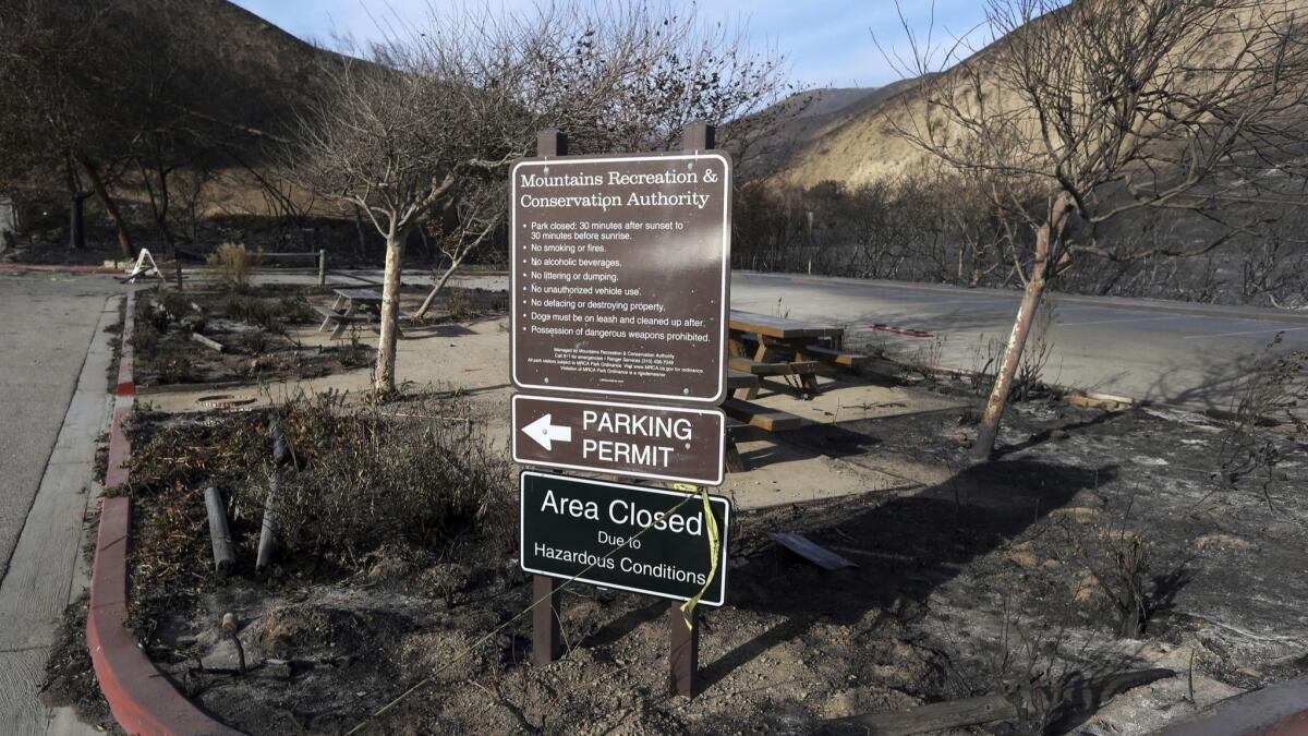 A sign near the entrance to the Corral Canyon Park recreation area stands amid a landscape charred by the Woolsey fire in Malibu.