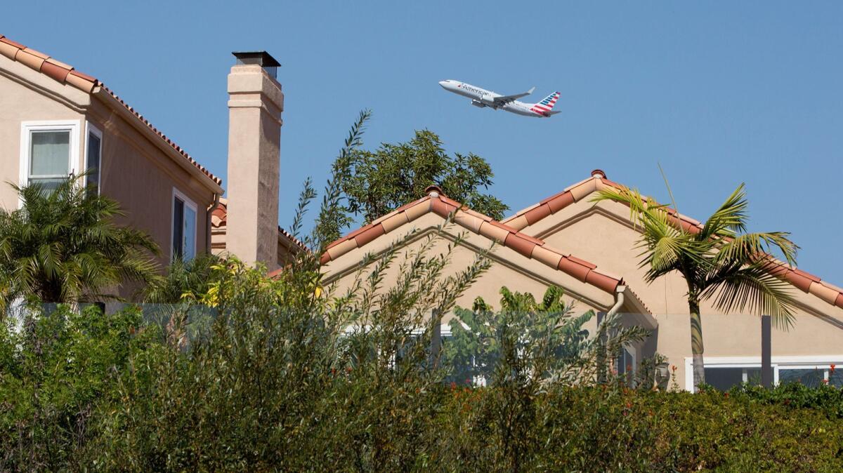 A commercial airplane flies over homes along Upper Newport Bay in Newport Beach after taking off from John Wayne Airport on Sept. 26.