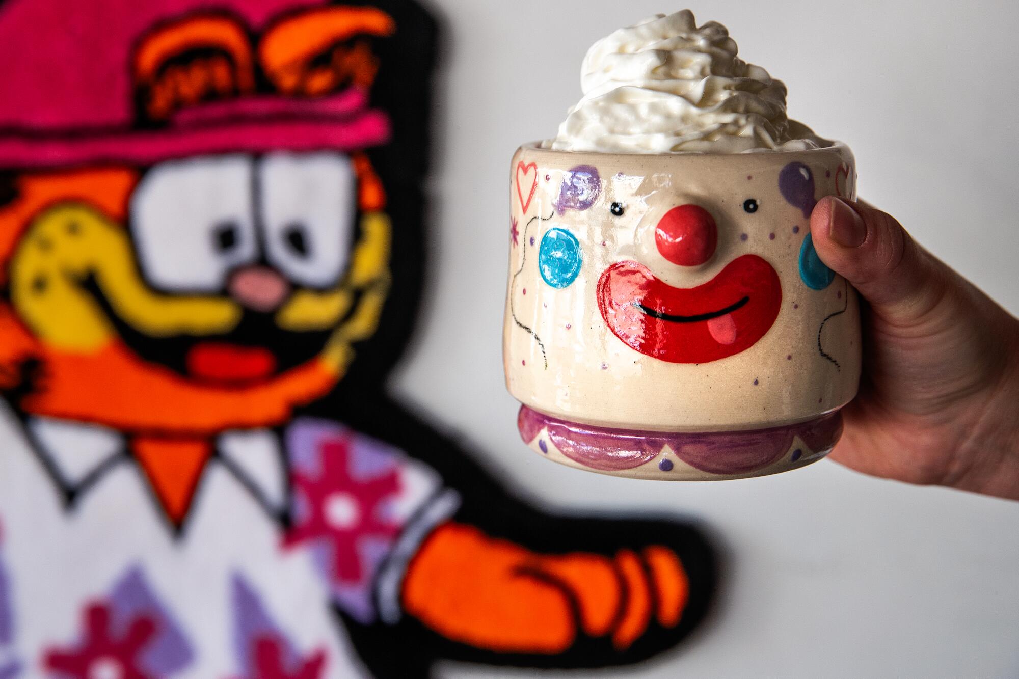 Uma das xícaras de Yousefi está em frente a um tapete Garfield, feito por sua irmã Jasmine, que vende tapetes em seu Instagram @ruggsters.