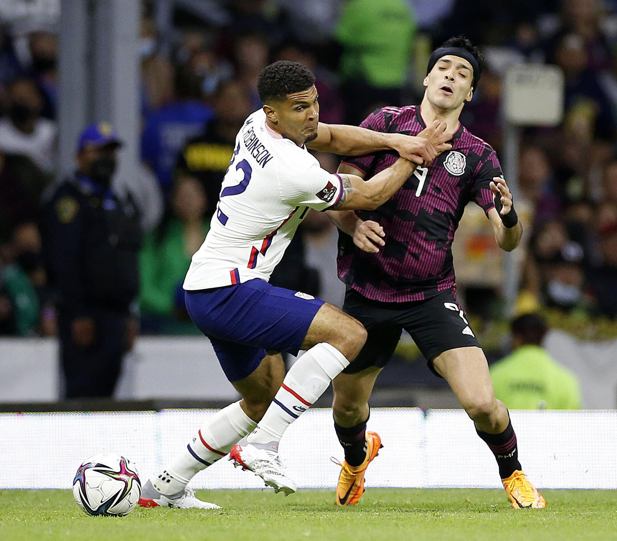 U.S. defender Miles Robinson receives a yellow card for fouling Mexico forward Raul Jimenez during the first half.