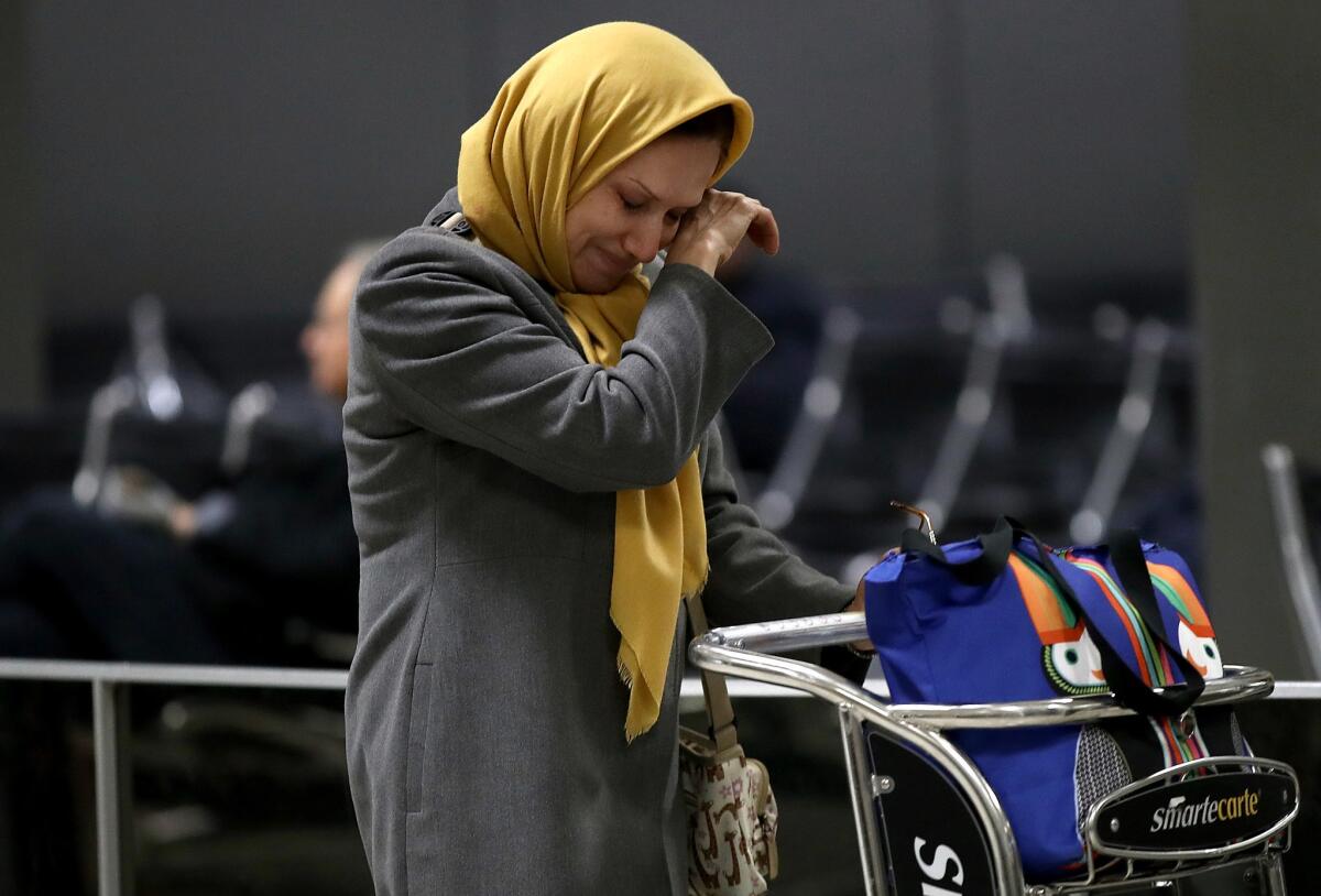 A woman traveling on a flight from Addis Ababa, Ethiopia wipes away a tear after greeting a relative in the international arrivals area of Dulles International airport on Feb. 6, 2017.