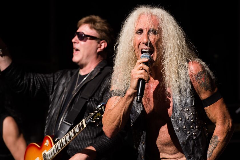 Dee Snider wearing a leather vest and singing into a microphone