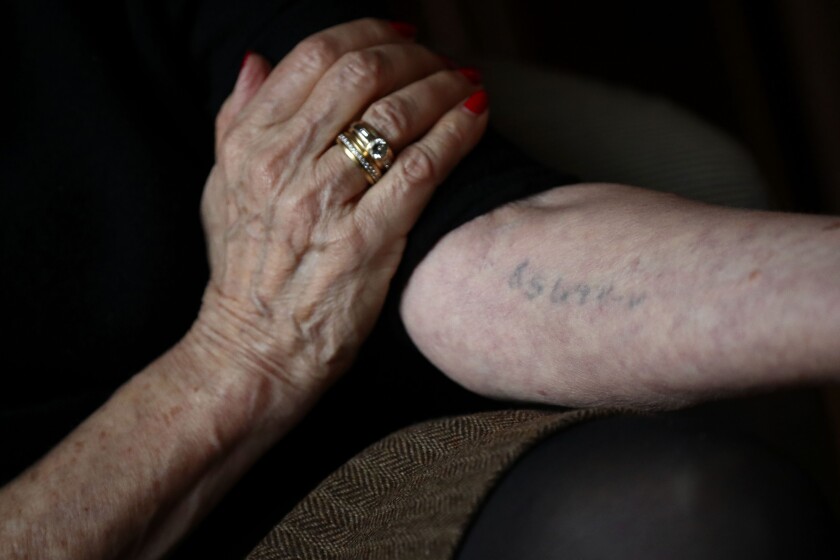 Auschwitz survivor Eva Umlauf shows her tattooed arm as she poses for a photo in Munich, Germany, on Jan. 8.
