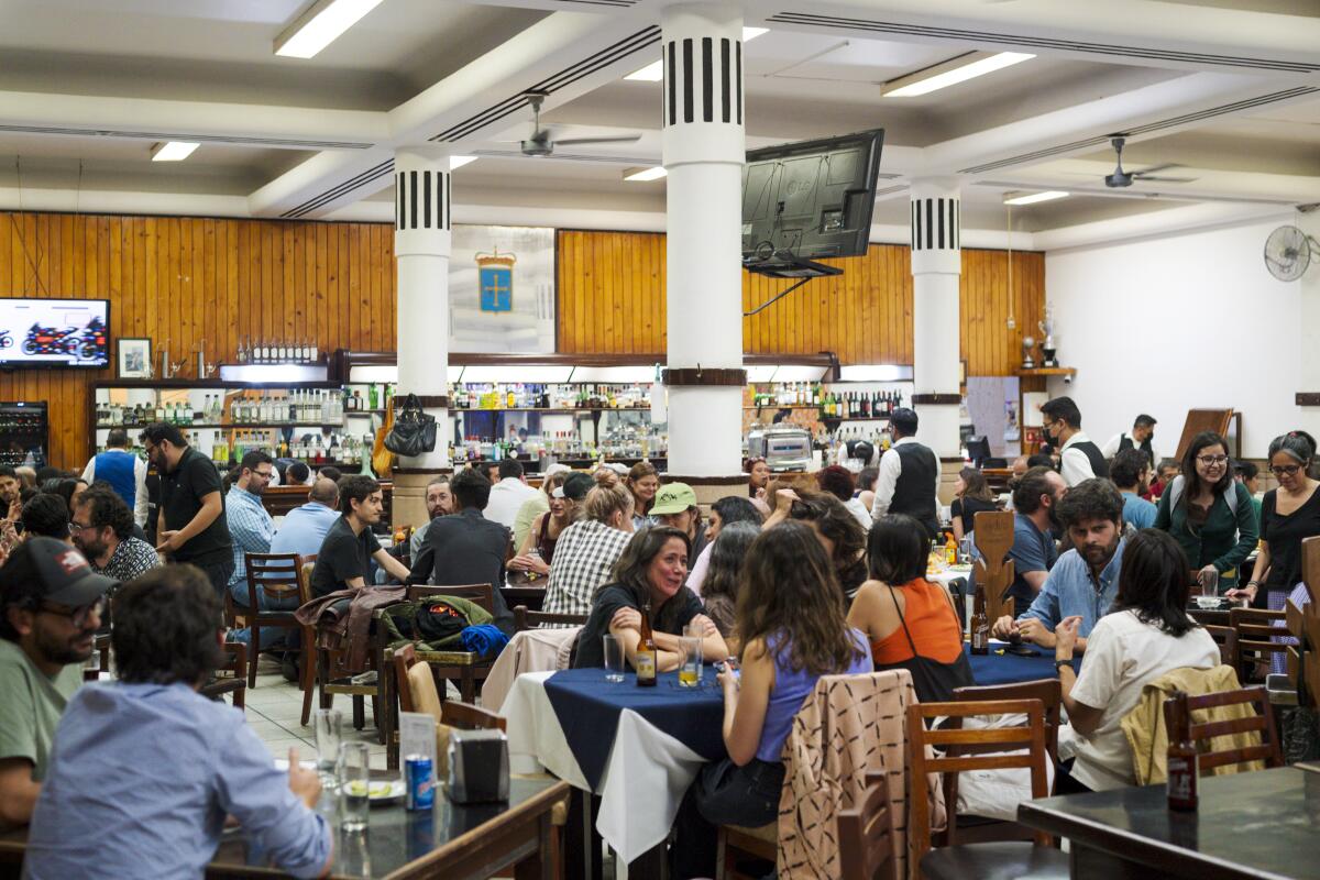 People gather at tables inside a Covadonga banquet room.