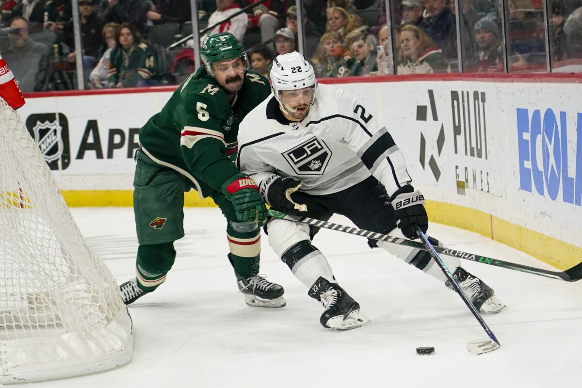Minnesota Wild defenseman Jacob Middleton tries to knock the puck away from Kings left wing Kevin Fiala.