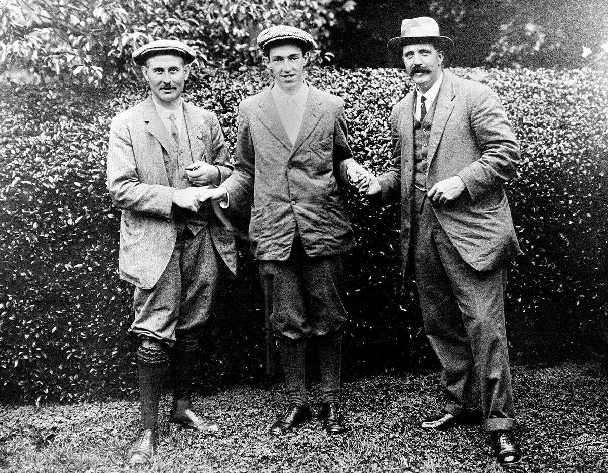FILE - American golfer Francis B. Ouimet, center, shakes hands with Harry Vardon, left, and Ted Ray, both of Britain, at the U.S. Open Golf Championship at The Country Club in Brookline, Mass., in 1913. Ouimet defeated the pair to become the new champion. The gallery was among the biggest ever in America for a golf tournament, and it was hailed as one of the biggest upsets in sport. The U.S. Open returns to The Country Club in June 2022. (AP Photo/File)