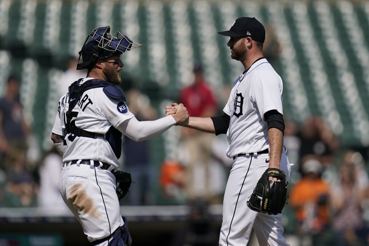 Detroit Tigers catcher Tucker Barnhart, left, and pitcher Drew Hutchison celebrate after the final out in the ninth inning of a baseball game against the Oakland Athleticsin Detroit, Tuesday, May 10, 2022. (AP Photo/Paul Sancya)