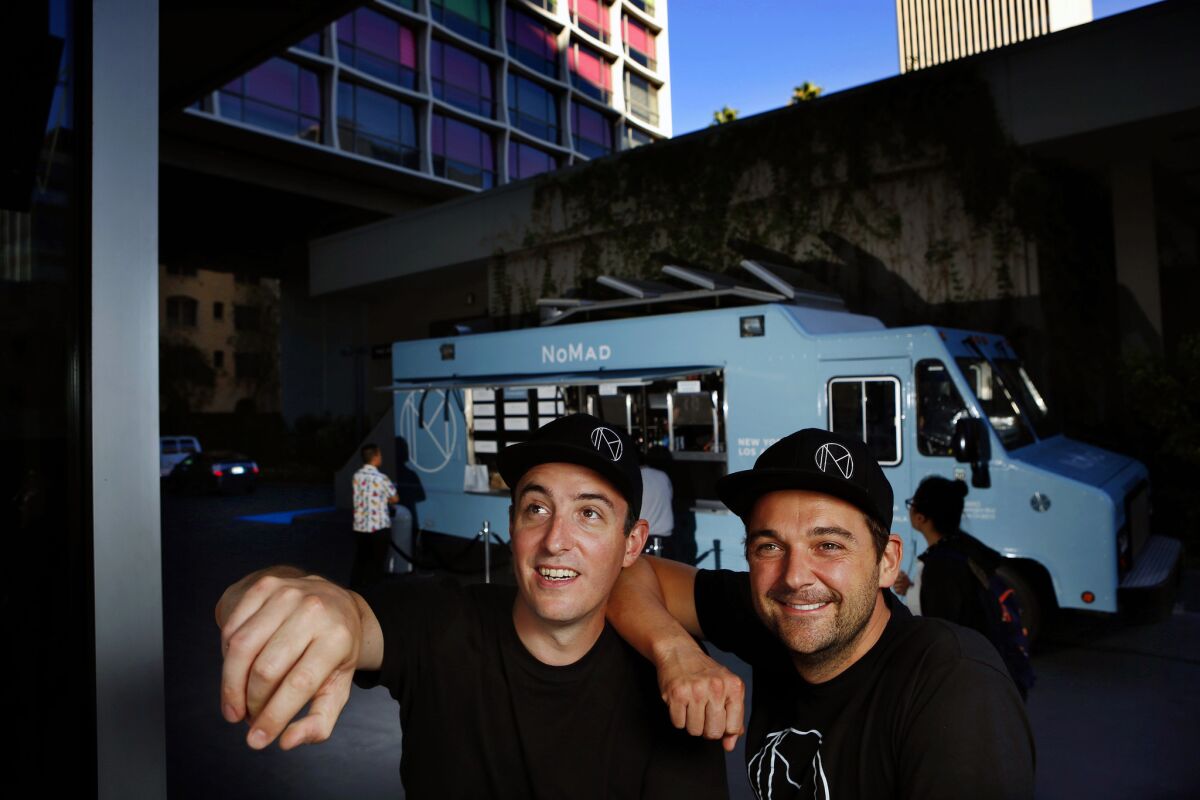 Chef Daniel Humm (right) and Will Guidara (left), co-owners of the Nomad food truck, are photographed near the truck outside of the Line Hotel in Koreatown.