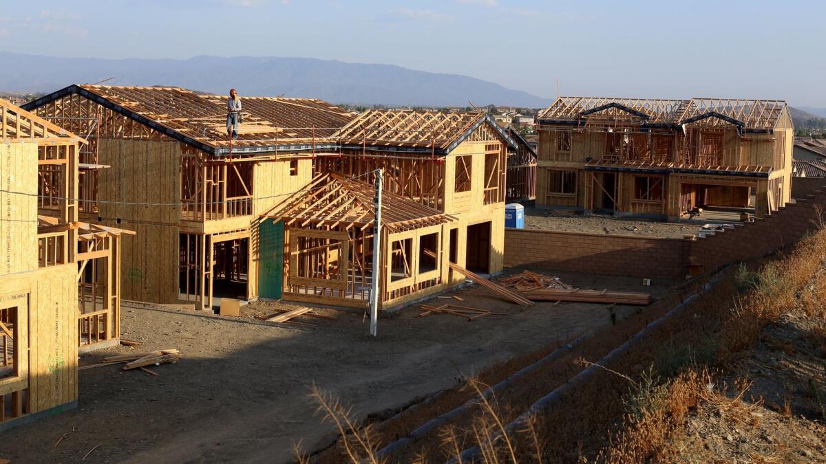 A UCLA economic forecast expects construction to increase, but not enough to keep a lid on homes prices. Above, home are under construction in Murrieta in August.
