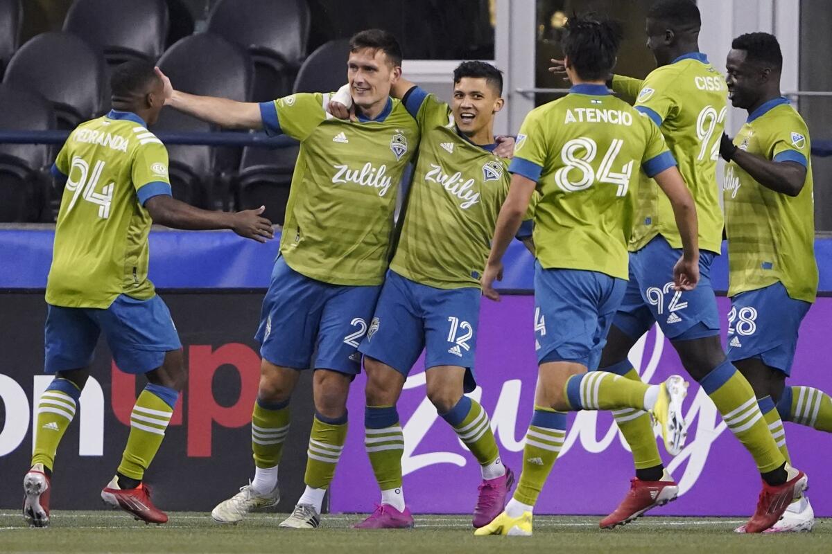 Seattle Sounders defender Shane O’Neill celebrates with forward Fredy Montero and other teammates after O’Neill scored