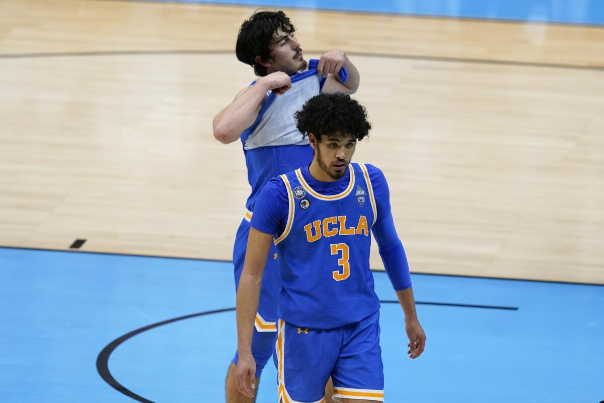 UCLA guards Johnny Juzang and Jaime Jaquez Jr. walk off the court after losing 