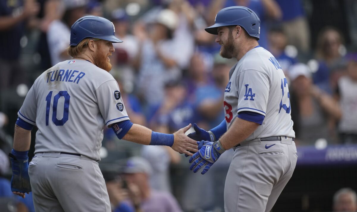 Dodgers' Justin Turner congratulates Max Muncy who crossed home plate.