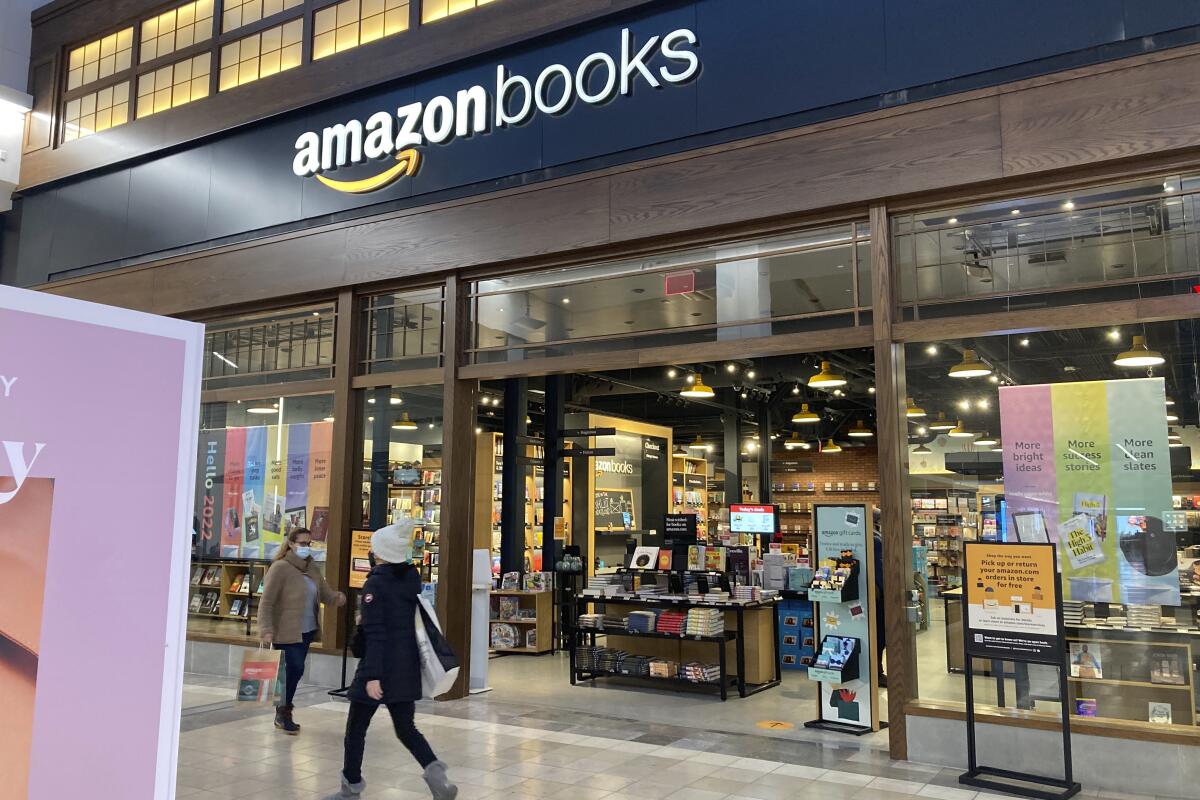 ARCHIVO - Personas pasan por el exterior de una tienda de libros Amazon