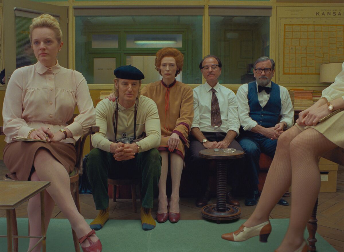 A group of people sit together in an office in a scene from the film  "The French Dispatch."