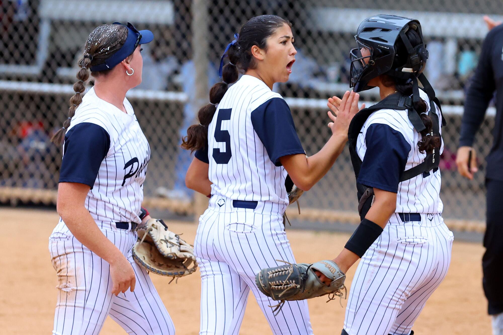 Pacifica High pitcher Brynne Nally (5) is congratulated by catcher Catherine Benitez after retiring the side.