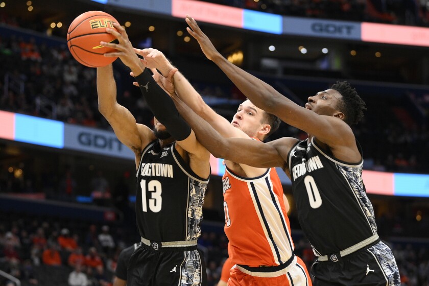 Georgetown guard Donald Carey (13) and guard Aminu Mohammed, right, battle for the ball with Syracuse forward Jimmy Boeheim, center, during the first half of an NCAA college basketball game, Saturday, Dec. 11, 2021, in Washington. (AP Photo/Nick Wass)