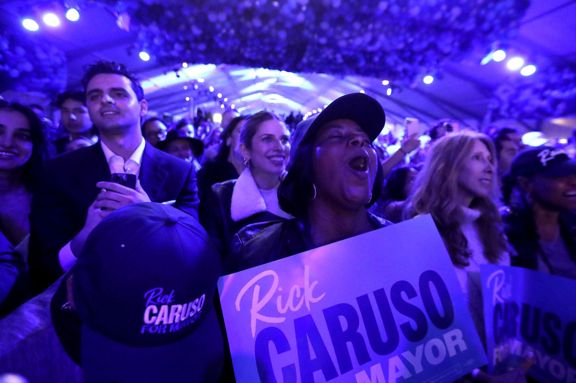Supporters cheer and hold "Rick Caruso for Mayor" signs.