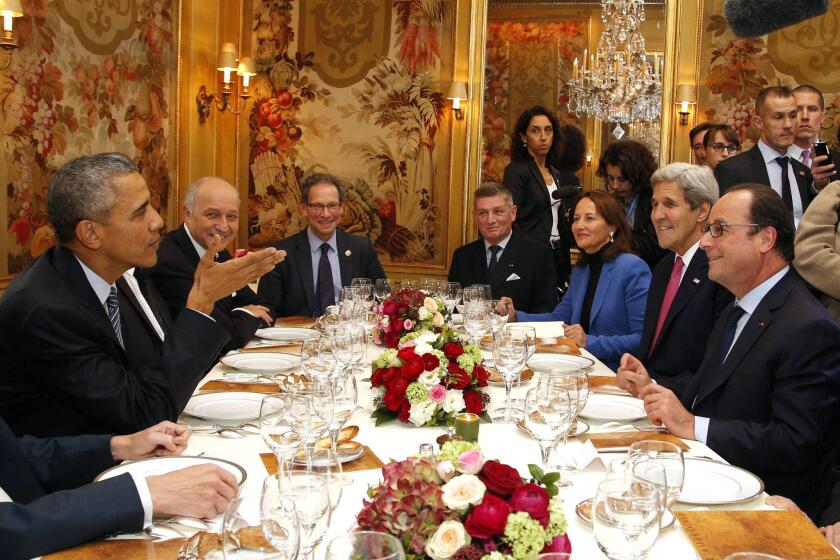 President Obama sits with French President Francois Hollande (right), Secretary of State John Kerry, and other officials as they have dinner at the Ambroisie restaurant in Paris on Nov. 30.