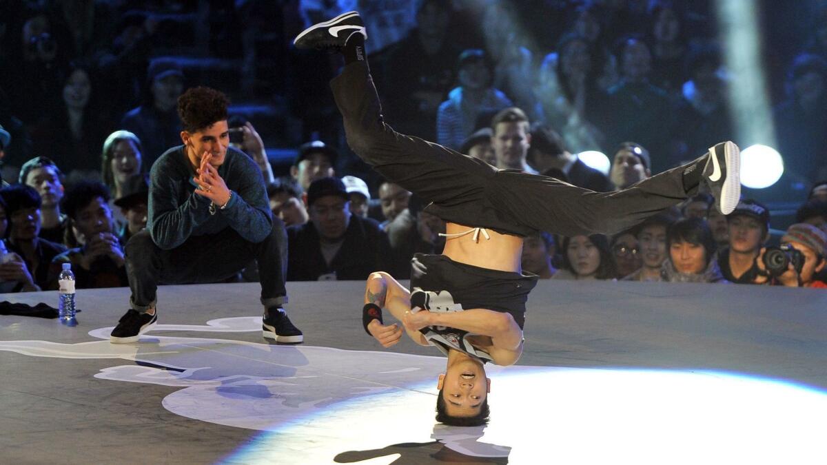 Hong-Yeol "Hong10" Kim of South Korea performs as Lil Zoo of Morocco watches during a 2013 breakdancing competition in Seoul.