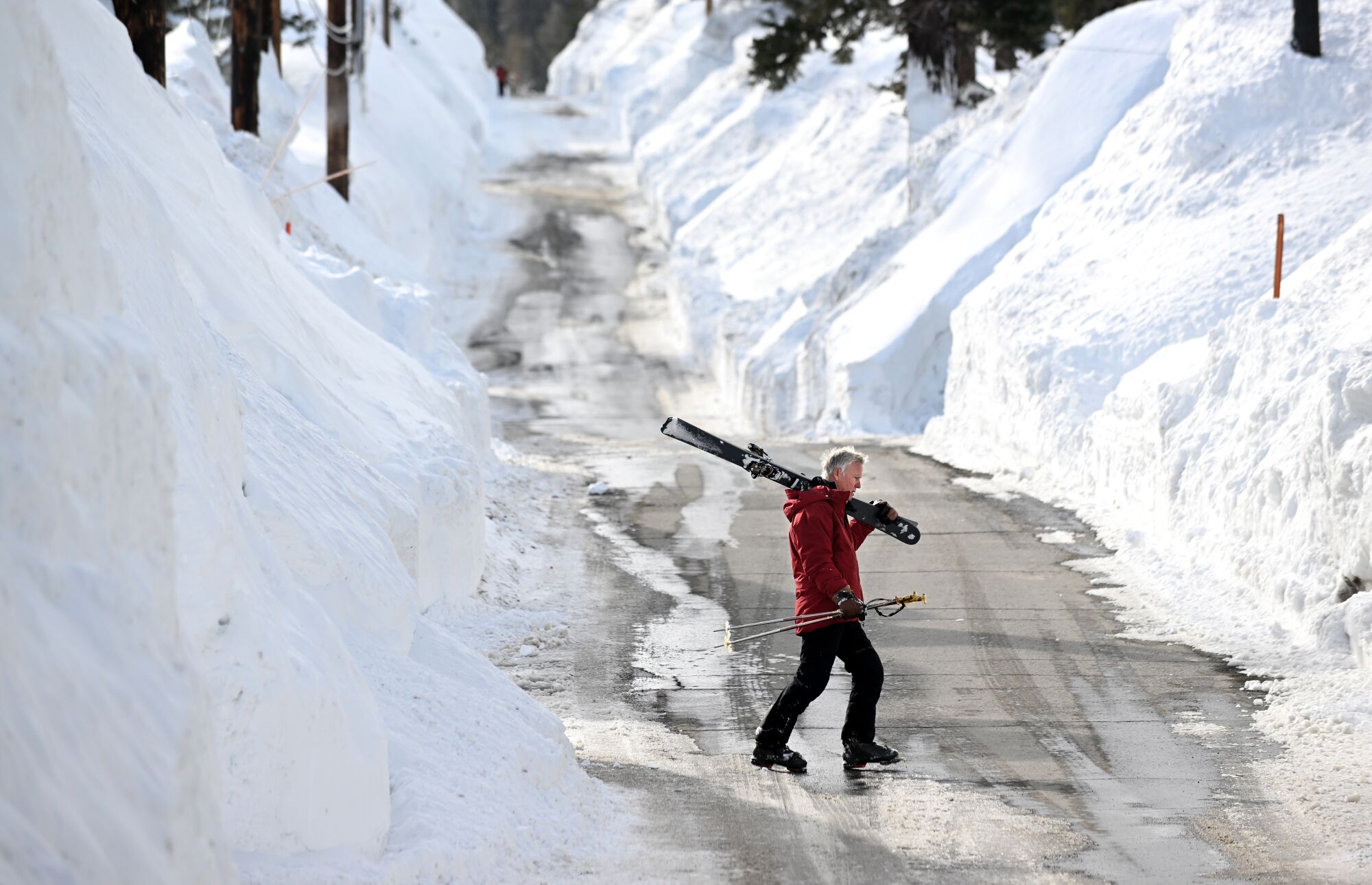 David Frazier walks across Davison Road after a day of skiing at Mammoth Mountain