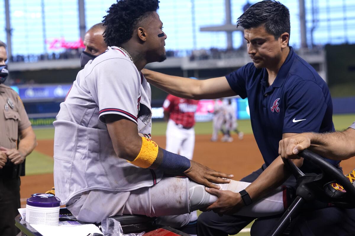 The Atlanta Braves' Ronald Acuna Jr. leaves the field on a medical cart July 10, 2021, in Miami. 