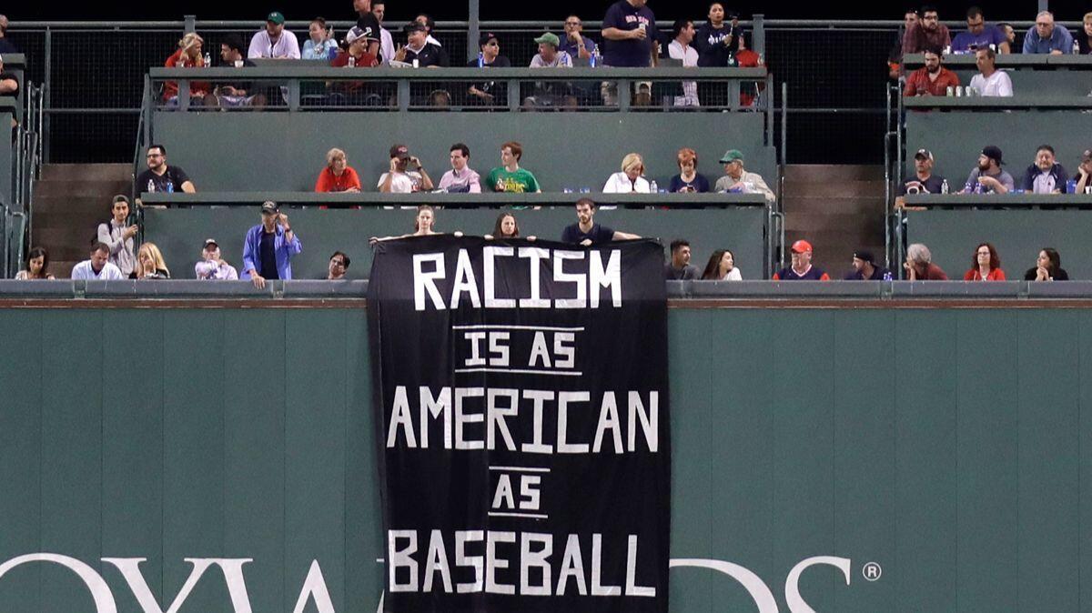 A banner is unfurled over the left field wall during the fourth inning of a baseball game between the Boston Red Sox and Oakland Athletics at Fenway Park in Boston on Wednesday.