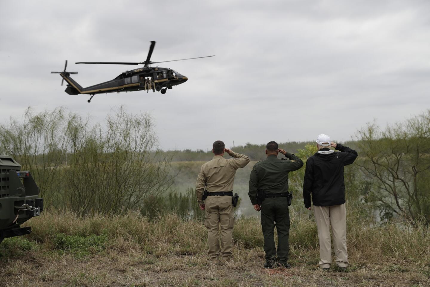 President Trump salutes a U.S. Customs and Border Protection helicopter as he tours the U.S.-Mexico border Jan. 10 in McAllen, Texas.
