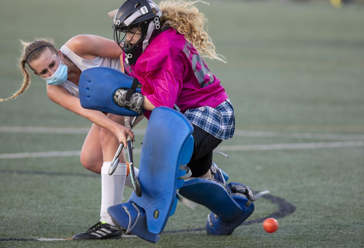 Huntington Beach's Taylor Rubly shoots and scores as Newport Harbor's Cadence Cockrell challenges her.
