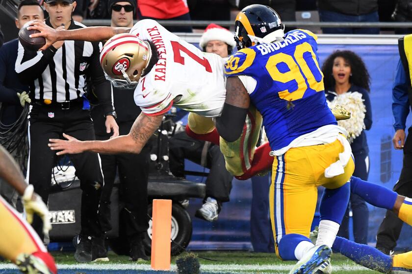 49ers quarterback Colin Kaepernick scores on a two-point conversion against Rams defensive lineman Michael Brockers late in the fourth quarter.