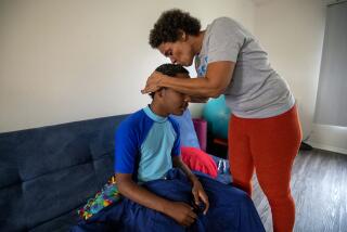 FULLERTON, CA-OCTOBER 11, 2023:Christine LyBurtus kisses her son Noah Jones, 14, while combing his hair at their home in Fullerton, shortly before he was picked up and driven to a residential care facility in Costa Mesa. LyBurtus has been struggling to find appropriate care for Noah, who has autism, after episodes in which he hurt her and his sister. (Mel Melcon/Los Angeles Times)