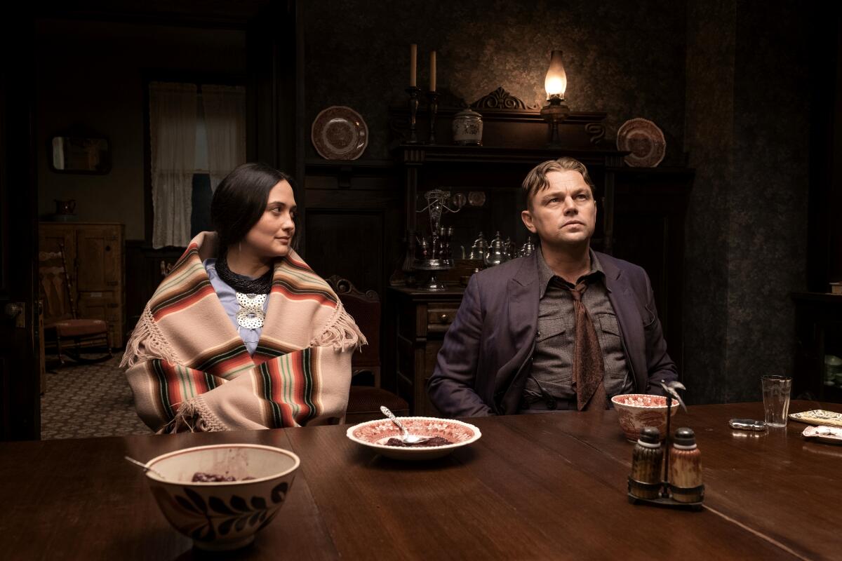 An Osage woman sits at a table with a white man.