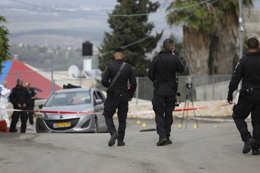 Police work at the scene in Umm el-Fahm, Israel, Friday, Dec. 3, 2021, after a man was shot dead by Israeli police in a car-ramming incident following a night of intense violence in the Arab populated Israeli town. (AP Photo/Mahmoud Illean)