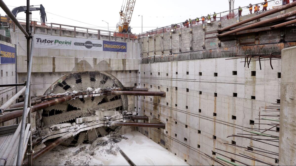A massive tunneling machine breaks through a 5-foot-thick concrete wall on April 4, the completion of a major phase in the construction of an underground roadway in Seattle.