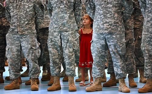 Morgan Styke, 5, is the odd one out in a military formation that includes her father, Sgt. Jeremy Charlet, at a dismissal ceremony of his National Guard unit Monday at the New Ulm Civic Center, in New Ulm, Minn. The New Ulm-based 125th Field Artillery Headquarters and Headquarters Battery unit returned to Minnesota Monday after 22 months of active duty, 16 of them in Iraq.