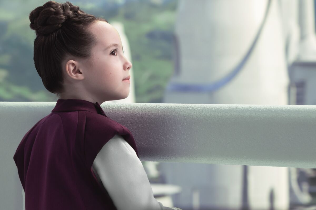 a girl standing by a rail
