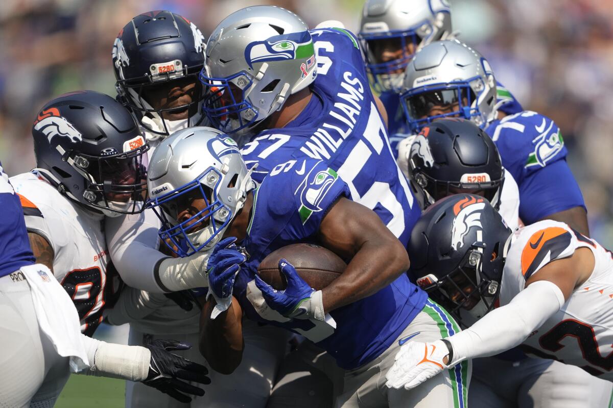 El corredor de los Seattle Seahawks, Kenneth Walker III (9), es tacleado por jugadores de los Denve