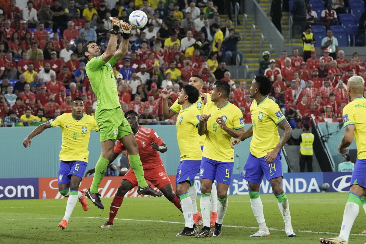 Brazil's goalkeeper Alisson, top, clears the ball during the World Cup group G soccer match 